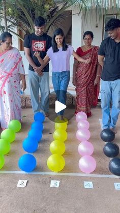 a group of people standing next to each other in front of a number line with balloons