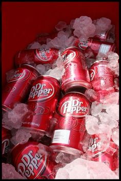 several cans of dr pepper sitting on top of ice