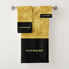 two black and gold towels hanging on a towel rack