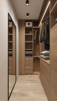 an empty walk in closet with wooden cabinets