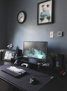 a desktop computer sitting on top of a desk next to a clock and pictures above it