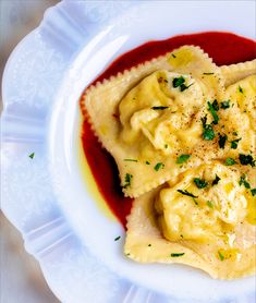 ravioli with sauce and parsley on a white plate