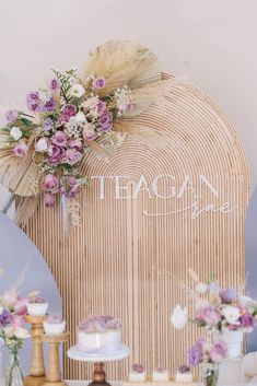 a table topped with cakes and flowers on top of a wooden shelf next to mirrors