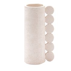 a white vase with five circles on it