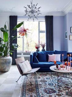 a living room filled with blue couches and lots of candles on top of them