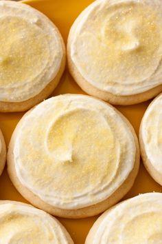 a yellow plate topped with cookies covered in white frosting