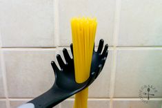 two black and yellow toothbrushes in a holder on a tiled wall with white tiles