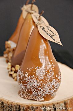 two pears are sitting on top of a piece of wood with white sprinkles