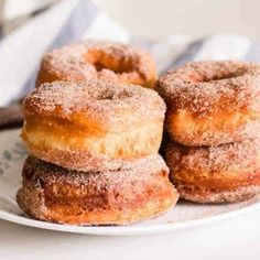 three sugared donuts on a white plate