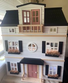 a doll house with several windows and shutters