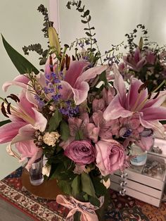 a vase filled with lots of pink flowers on top of a table next to a mirror