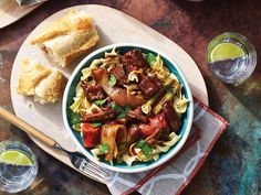 two bowls filled with pasta and meat on top of a table