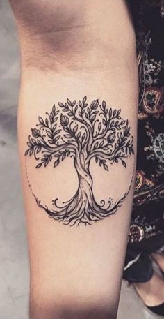 a woman's leg with a tree tattoo on it