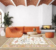 an orange couch sitting on top of a wooden floor next to a fire place in a living room