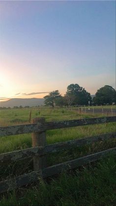 a wooden fence sitting in the middle of a lush green field