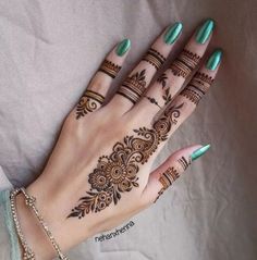 a woman's hand with henna tattoos on it