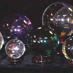 there are many different colored glass balls on the table