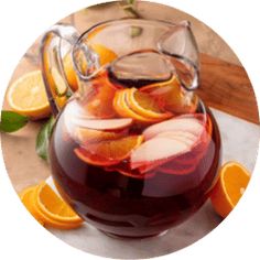 a pitcher filled with liquid surrounded by sliced oranges