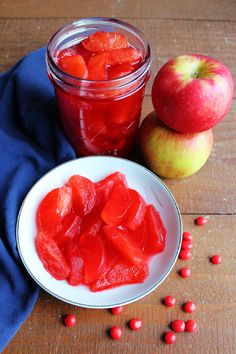 a bowl of fruit next to a jar of jelly