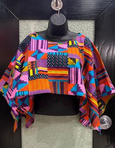 A multicolor African print Shrug. This is a light weight top that is great as a accessory . It is great for layering and has endless possibilities . It can be worn by women or youth, by clergy and for finer outings. The fabric is 100% cotton and machine washable . Shop with me for other items www.evelyncreationinc@etsy.com.  it fits med to XL, Larger sizes are made to your request. Don't delay order yours today Bohemian Cotton Top With Geometric Pattern, Multicolor Geometric Pattern Summer Top, Multicolor Patterned Blouse For The Beach, Bohemian Multicolor Print Tops For The Beach, Bohemian Multicolor Print Tops For Beach, Bohemian Blouse With Vibrant Print, Bohemian Blouse With Vibrant Patterned Print, Multicolor Printed Tops For Festival, Bohemian Printed Crop Top For Festival