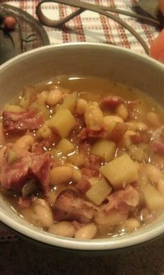 a white bowl filled with ham and beans