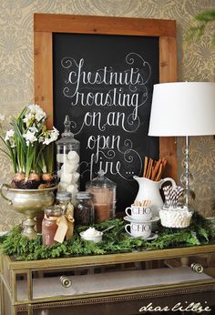 an old dresser is decorated with greenery and chalkboard signs for the wall behind it