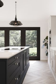 a large kitchen with black cabinets and white counter tops