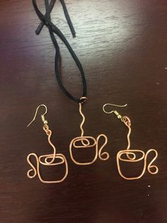 three wire wrapped coffee mugs sitting on top of a wooden table