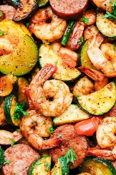 shrimp, zucchini, and squash stir fry in a skillet with parsley on top