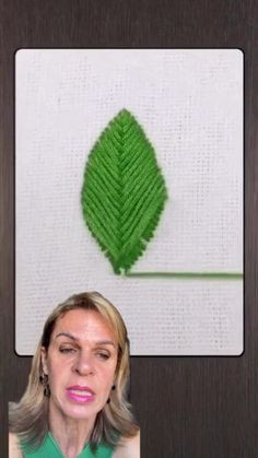 a woman is looking at a piece of art that looks like a leaf on the wall