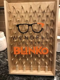 an eyeglass display in the shape of a blindfold with words reading we'vendell eye care blinko