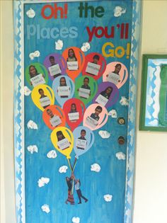 a bulletin board with pictures of people hanging from the balloons on it's front door