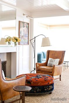 a living room filled with furniture and a fire place next to a mirror on the wall