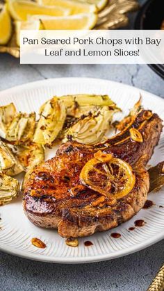 grilled pork chops with bay leaf and lemon slices on a white platter