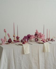 a table topped with lots of pink flowers and candles