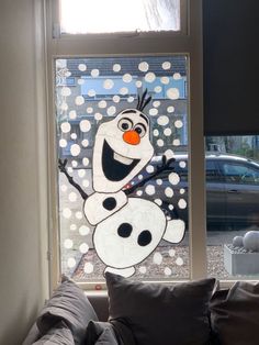 a window with a frosty snowman drawn on it