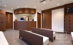 a living room with white couches and wooden cabinets in it's center area