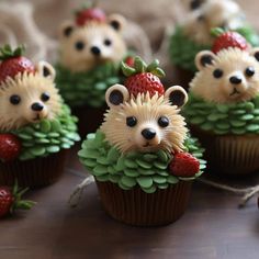 cupcakes decorated like hedgehogs with strawberries and pine cones on top