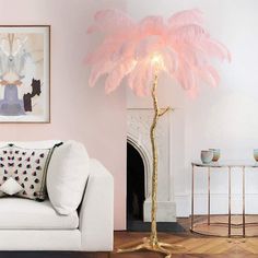 a living room with a white couch and a pink feather lamp in front of a fireplace