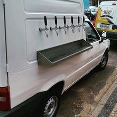 the back end of a white van parked in a parking lot next to other cars