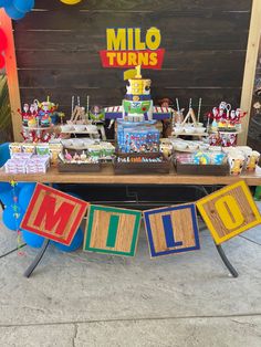 a table topped with lots of cakes and desserts next to a sign that says millo turns