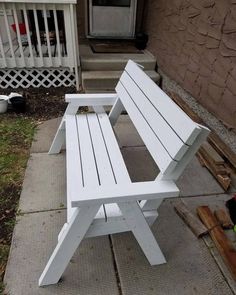 a white bench sitting on top of a sidewalk