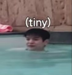 a young man swimming in a pool with the caption tiny