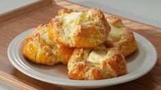 a white plate topped with biscuits on top of a wooden tray