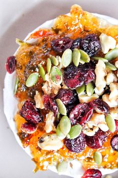 a white plate topped with fruit and nuts