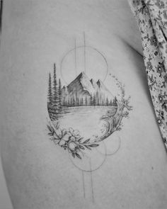 a woman's stomach with a mountain scene tattoo on it