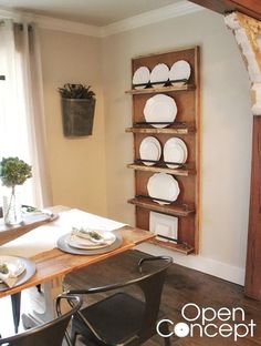 a dining room table with plates and place settings on the shelf in front of it