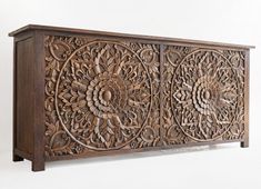 an intricately carved wooden cabinet against a white wall