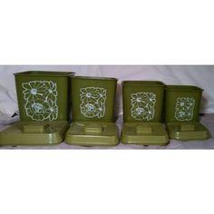 four green containers with flower designs on them