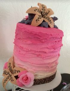 a multi layer cake with pink frosting and flowers